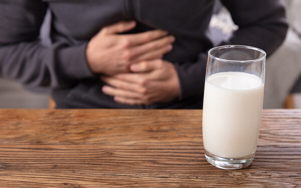 Midsection View Of A Man Suffering From Stomach Pain Holding Glass Of Milk